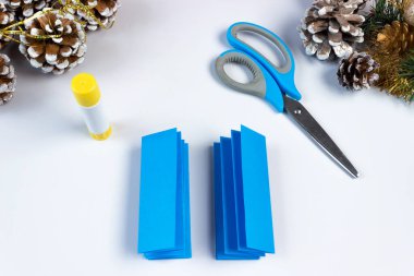 Renkli kâğıt ve kendi ellerinizle yapıştırıcıyla nasıl Noel kar tanesi yapılacağı. Diy konsepti. Adım adım kıvrak zeka. Adım 10. Bir şeridi sol tarafa, diğer şeridi de sağ tarafa koyuyoruz. Böylece soldaki şerit ortaya çıkıyor. 