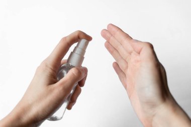Beyaz arka planda antiseptik bulunan ellerin dezenfeksiyonu. Coronavirus salgını önleme kavramı.