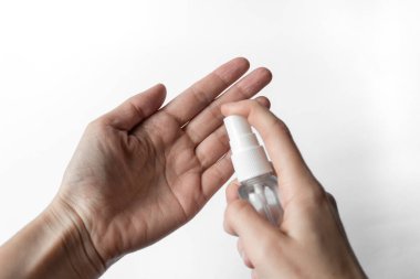 Beyaz arka planda antiseptik bulunan ellerin dezenfeksiyonu. Coronavirus salgını önleme kavramı.