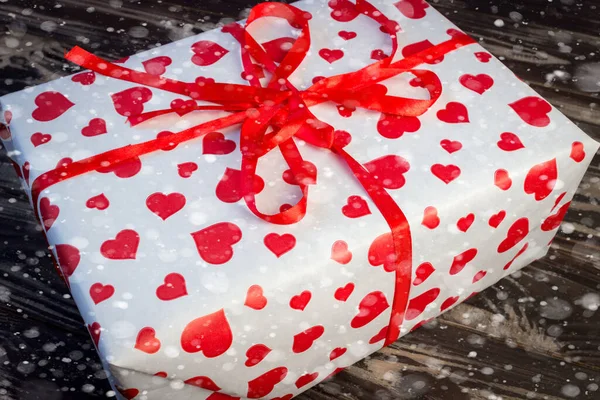 Caixa Presente Branca Com Corações Vermelhos Bokeh Neve Fundo Madeira — Fotografia de Stock