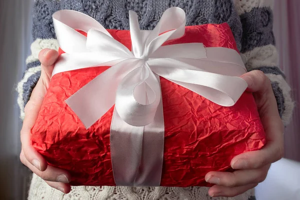 赤いギフトボックスを手にしたニットのセーターを着たヨーロッパの女の子のクローズアップ ショッピングのコンセプト 新年とクリスマスの贈り物 — ストック写真