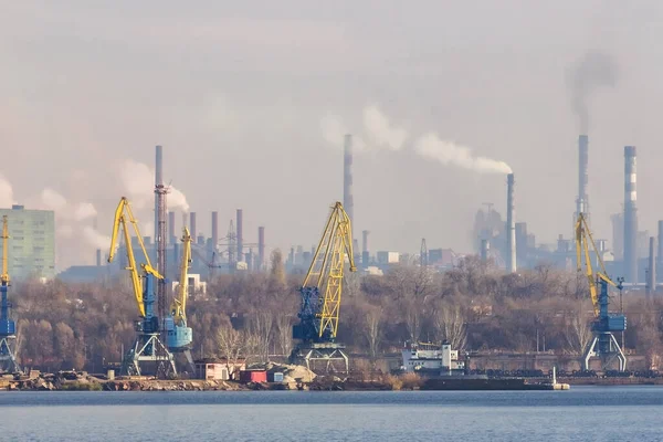 View of the industrial city of Zaporozhye, Ukraine. Smog emissions from chimneys, air pollution. Poor environmental situation. Metallurgical factories and cargo port.