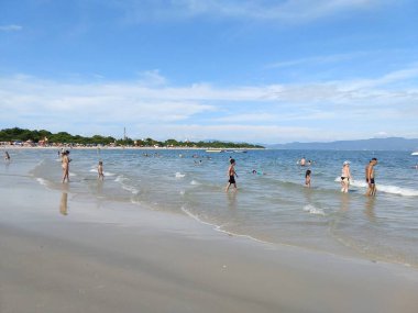 Bir grup turist, güneşli bir yaz gününde Santa Catarina Brasil 'de sahilde dikiliyorlar.