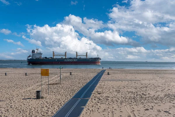 stock image Cargo ship cruises in front of the beach at Boulevard Evertsen in Vlissingen. Provinz Zeeland in the Netherlands