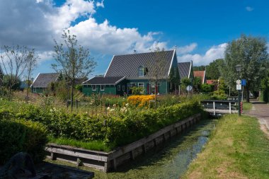 Zaandam 'ın Kalverpolder bölgesindeki Haaldersbroek caddesinde bahçeli köy manzarası ve geleneksel evler. Hollanda 'nın Kuzey Hollanda Eyaleti