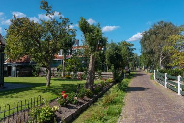 Zaandam 'ın Kalverpolder bölgesindeki Haaldersbroek caddesinde bahçeli köy manzarası ve geleneksel evler. Hollanda 'nın Kuzey Hollanda Eyaleti