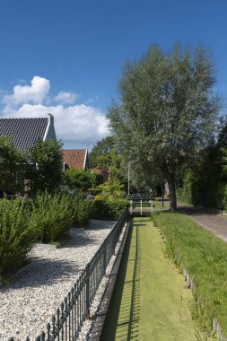 Zaandam 'ın Kalverpolder bölgesindeki Haaldersbroek caddesinde bahçeli köy manzarası ve geleneksel evler. Hollanda 'nın Kuzey Hollanda Eyaleti