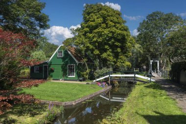 Zaandam 'ın Kalverpolder bölgesindeki Haaldersbroek caddesinde bahçeli köy manzarası ve geleneksel evler. Hollanda 'nın Kuzey Hollanda Eyaleti