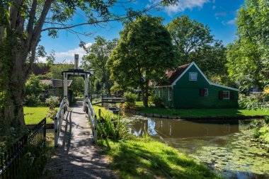 Zaandam 'ın Kalverpolder bölgesindeki Haaldersbroek caddesinde bahçeli köy manzarası ve geleneksel evler. Hollanda 'nın Kuzey Hollanda Eyaleti