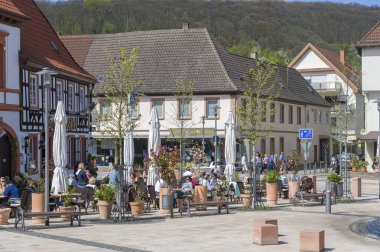 Kötü Bergzabern 'deki kasaba meydanındaki restoranda konuklar oturuyor. Almanya 'nın Rhineland-Palatinate eyaletindeki Pfalz bölgesi