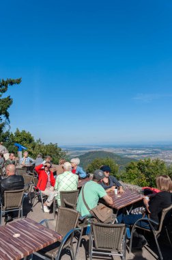 Turistler, Orschwiller yakınlarındaki Chateau du Haut Koenigsbourg 'un önünde. Arka planda Yukarı Ren Ovası ve Dağlık Kara Orman manzarası var. Fransa 'nın Bas-Rhin Bölgesi