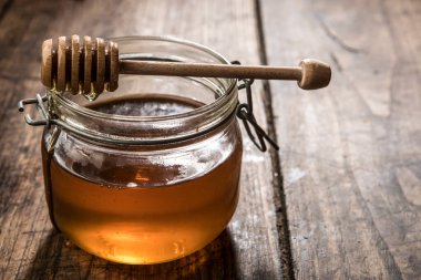 İtalyan balı cam kavanozda, tahta arka planda şeker kutusu var.