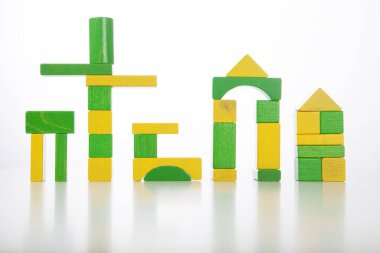 Beyaz arka planda izole edilmiş renkli oyuncak tuğlalarından oluşan şehir