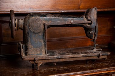 Antika paslı dikiş makinesi eski ahşap dolaba izole edilmiş.