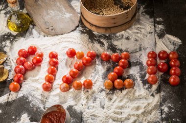 Un, domates sosu, yağ, mantar gibi malzemelerle dolu bir masada 