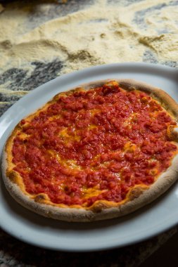 Pizza tabağı ahşap masada izole edilmiş.