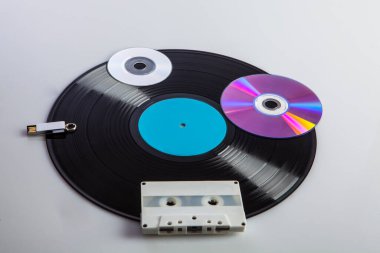 Beyaz arka planda izole edilmiş kasetler, dvd 'ler, kalem sürücüleri gibi farklı çağlardan gelen çeşitli dijital medyalar ile vinil kayıt