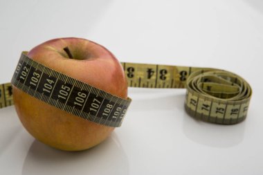 Beyaz zemin üzerinde bir spiral oluşturan mezuralı elma