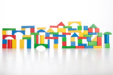 Beyaz arka planda izole edilmiş renkli oyuncak tuğlalarından oluşan şehir