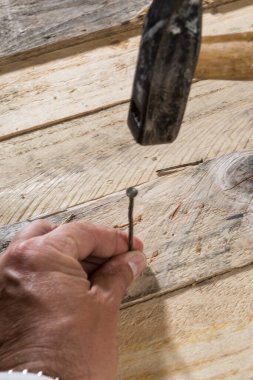 Marangoz tahtaya çivi çakıyor. 