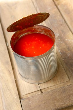 Ahşap zemin üzerinde domates sosu olan kutu. 