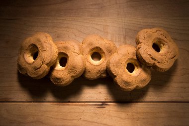 Tarçınlı ev yapımı kurabiyeler ve ahşap zemin üzerinde şeker tozu. 