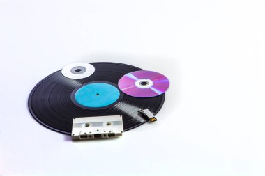 Beyaz arka planda izole edilmiş kasetler, dvd 'ler, kalem sürücüleri gibi farklı çağlardan gelen çeşitli dijital medyalar ile vinil kayıt