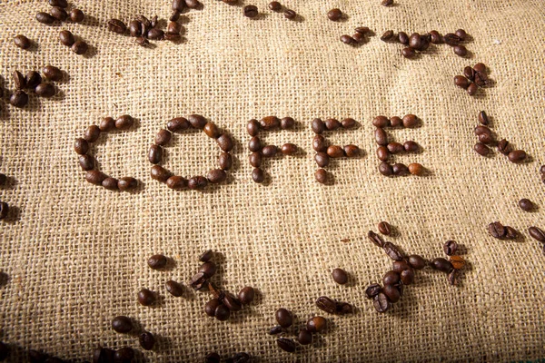 Написанное Кофе Кофейными Зёрнами Над Мешком Джута — стоковое фото