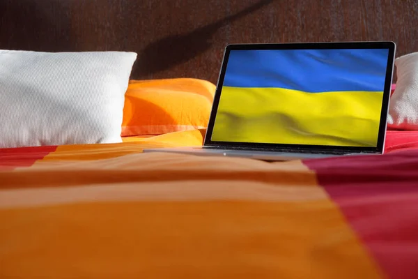 Notebook Odpočívající Posteli Vlajkou Ukrajiny — Stock fotografie