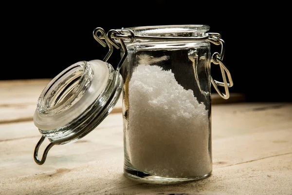 Kleiner Glasbehälter Für Grobes Salz Über Holztisch Isoliert Auf Schwarzem — Stockfoto