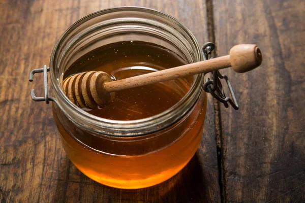 İtalyan balı cam kavanozda, tahta arka planda şeker kutusu var.