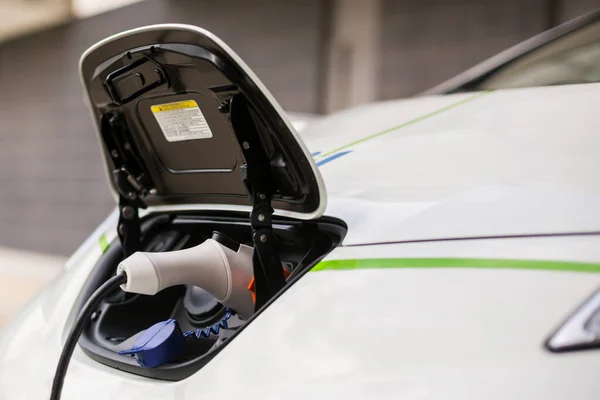 Şarj Istasyonundan Şarj Edilirken Beyaz Bir Elektrikli Arabanın Şarj Edicisinin — Stok fotoğraf