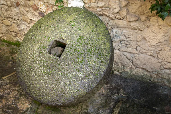 Starożytny Kamień Młyński Produkcji Oleju Opierający Się Kamiennej Ścianie — Zdjęcie stockowe