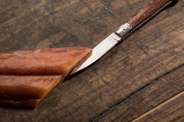 瓶装水 木桌上有传统沙丁鱼刀 — 图库照片