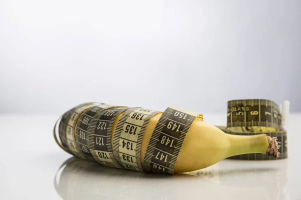 Banana Envolto Uma Fita Métrica Isolada Fundo Branco — Fotografia de Stock