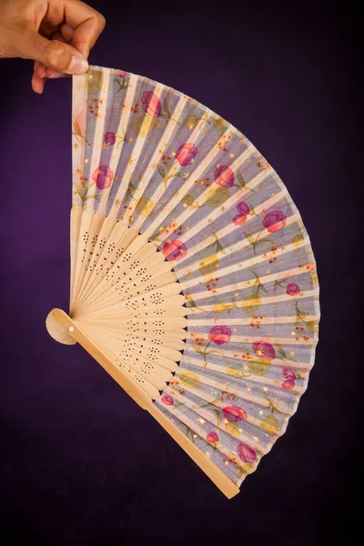 stock image Hand fan with floral designs on a dark purple background