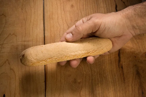 Ręka Trzymająca Bochenek Domowego Chleba Drewnianym Tle — Zdjęcie stockowe
