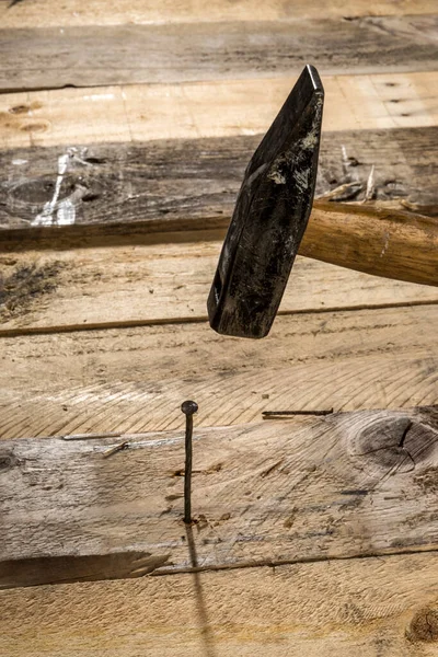 锤子把钉子钉在木板上 — 图库照片