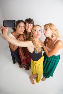 Bir grup mutlu genç arkadaş stüdyoda birlikte eğleniyorlar.