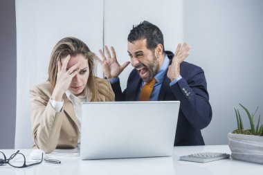 Bir çift iş arkadaşı, ofisin önünde dizüstü bilgisayarla oturup tartışarak elde edilen sonuçlardan memnun.