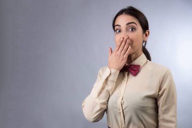 Gömlekli ve kırmızı papyonlu beyaz garson çabucak hafif arka planda izole bir şekilde gizlice yemek yiyor.