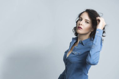 Siyah saçlı, kot gömlekli, koyu renkli arka planda izole edilmiş beyaz bir manken.