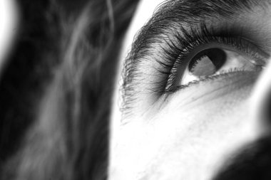 Bıyıklı ve uzun saçlı adam ciddi görünüyor.