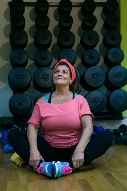 Yetişkin kadın portresi spor salonunda yoga yapıyor.