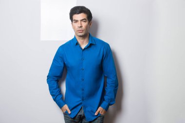 Gri arka planda genç yakışıklı bir adam