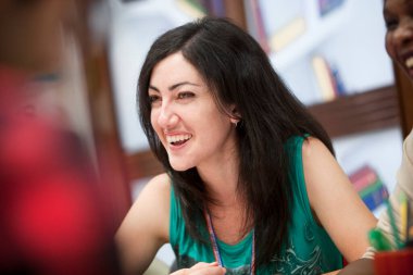 Sınıfta gülümseyen beyaz kadın.