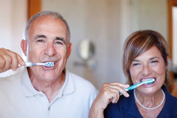 幸せな老夫婦が家で歯を磨く姿を — ストック写真