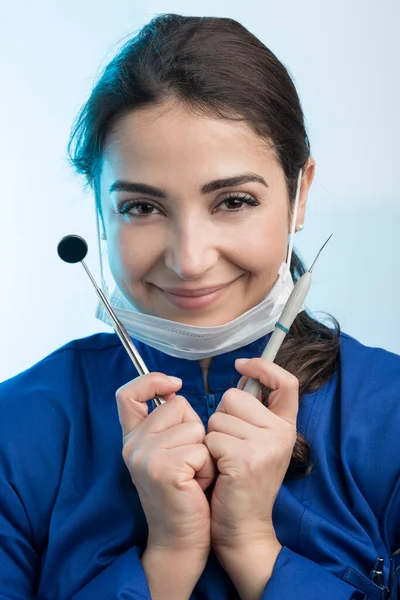 Vrouwelijke Tandarts Een Chirurgisch Masker Blauwe Jas Toont Werktuigen Geïsoleerd — Stockfoto