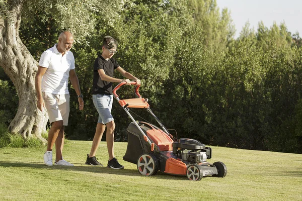 Vater Mit Sohn Mäht Das Gras Mit Dem Rasenmäher Heimischen — Stockfoto