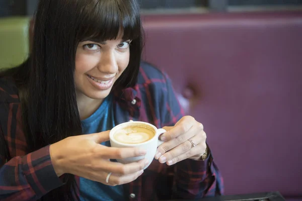 在餐馆里喝了一杯咖啡的漂亮的年轻黑发女人的肖像 — 图库照片